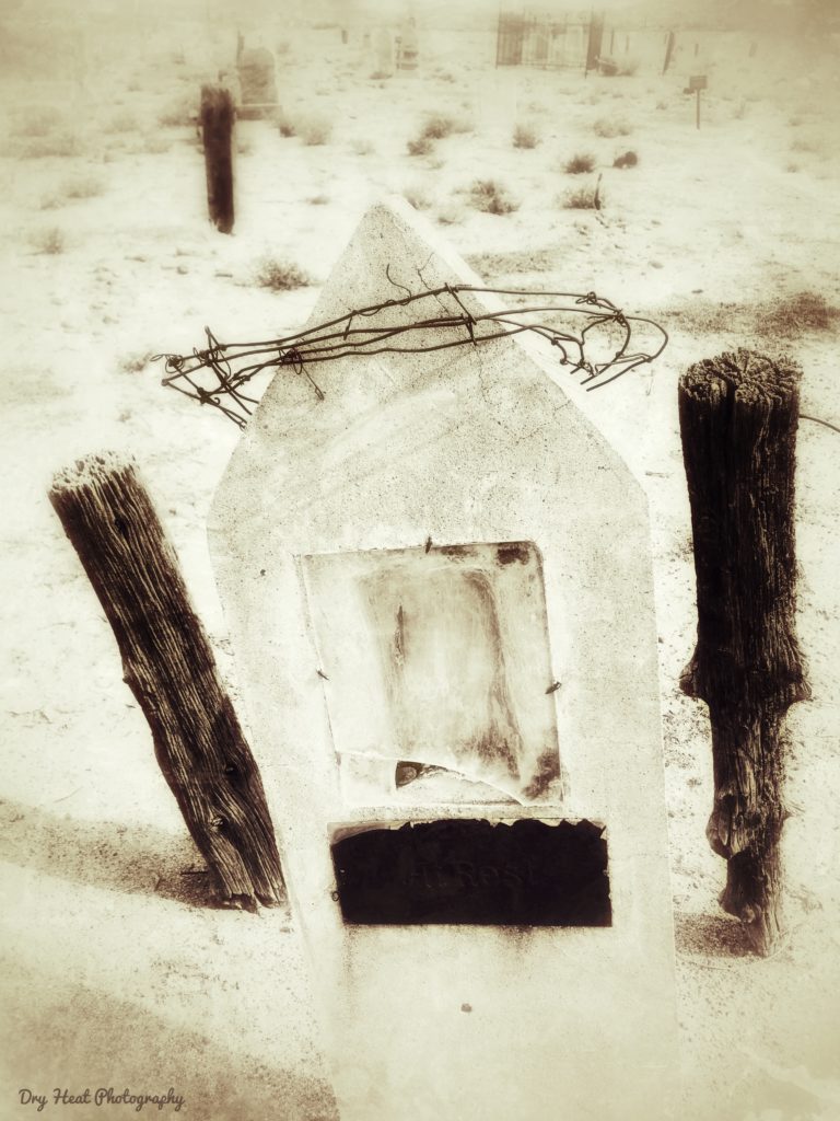 Concrete grave marker with a barbed wire crown at Our Lady of Guadalupe Cemetery in Peralta, New Mexico.