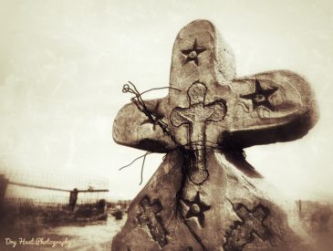 Ornate concrete cross grave marker at Our Lady of Guadalupe Cemetery in Peralta, New Mexico.