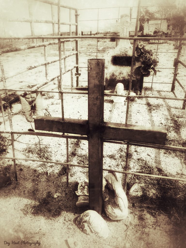 Fenced in grave marker at Our Lady of Guadalupe Cemetery in Peralta, New Mexico.