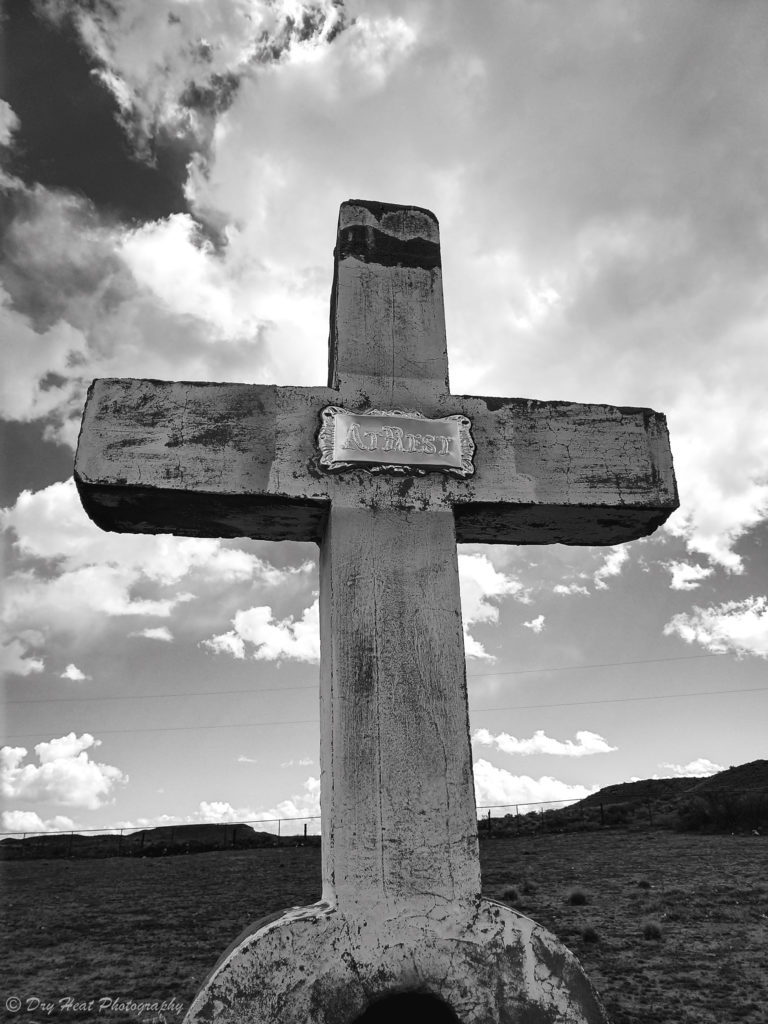 A concrete cross grave marker at Our Lady of Guadalupe Cemetery in Peralta, New Mexico.